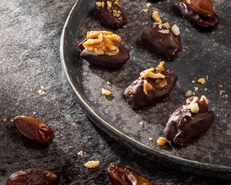 Dattel mit Walnuss auf einem dunklen Teller angerichtet