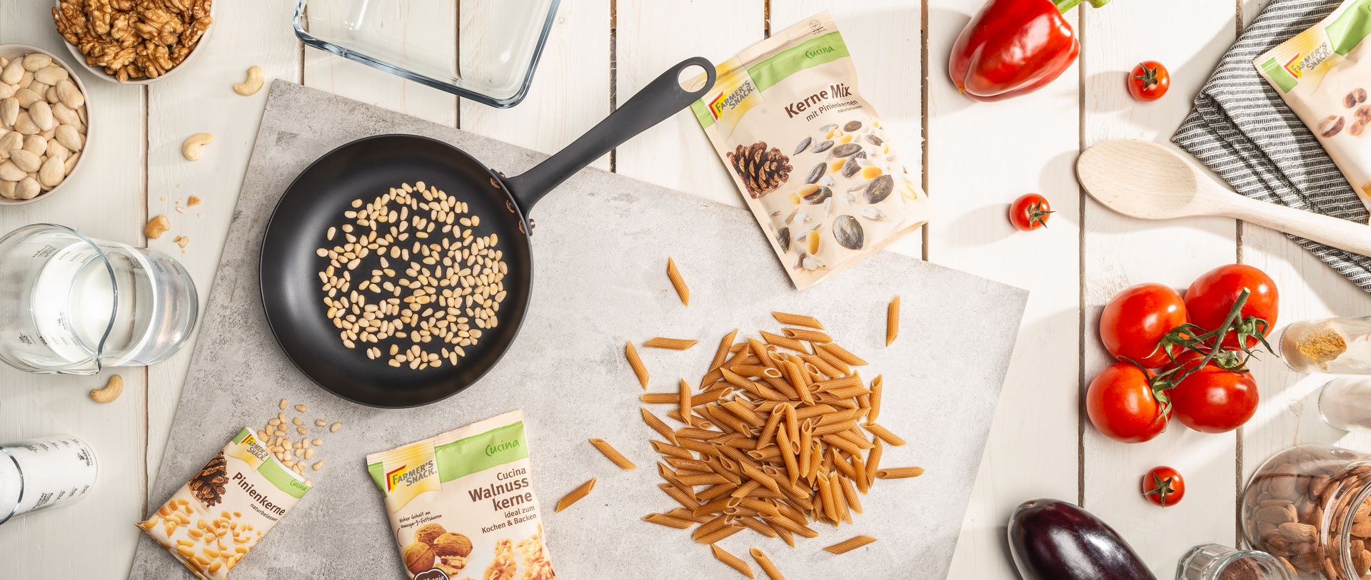 Sicht von oben auf Tisch mit Cucina Produkten, Küchenutensilien und Tomaten