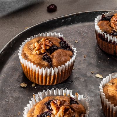 Ein schwarzer Teller mit Blaubeermuffin angerichtet Ein schwarzer Teller mit Blaubeermuffin angerichtet