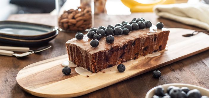 Blueberry Banana Cake auf einem hellem Holzbrett angerichtet