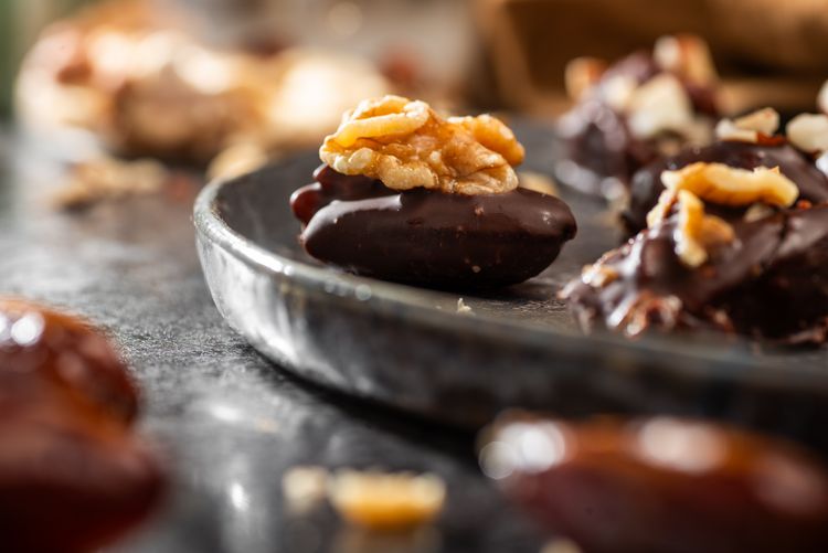 Nahaufnahme einer Dattel mit Schokoladenglasur und Walnuss